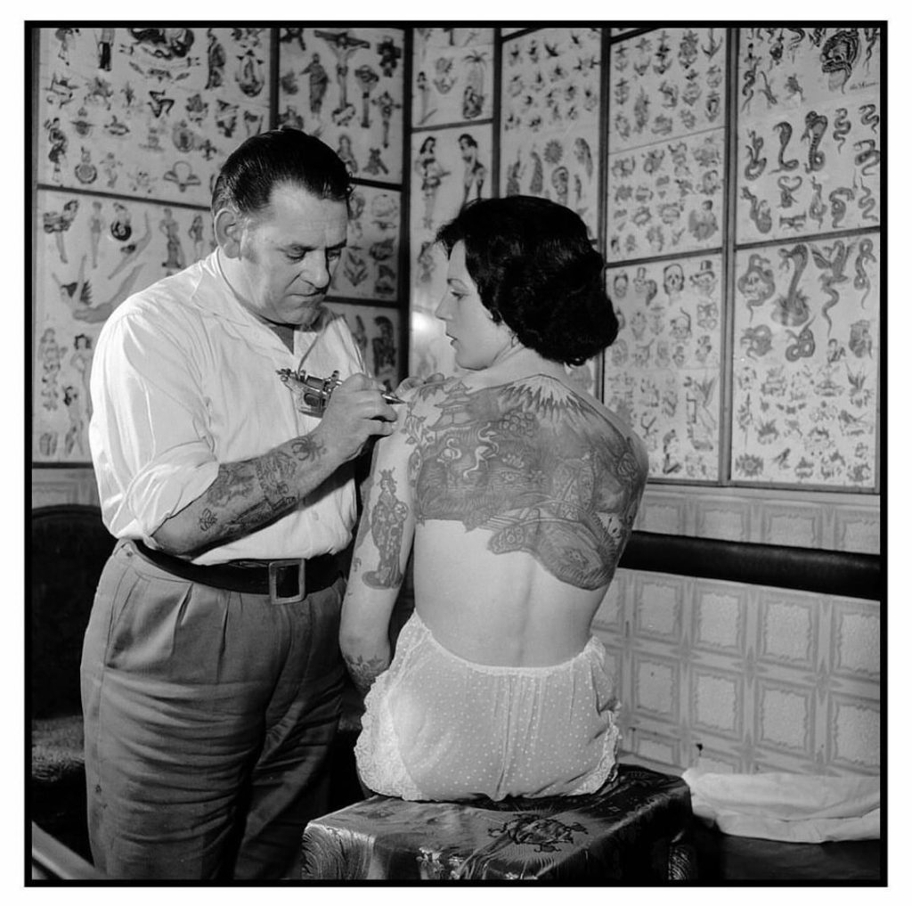 Les Skuse tattooing Pam Nash, 1959 vintage tattoo historical archive photograph