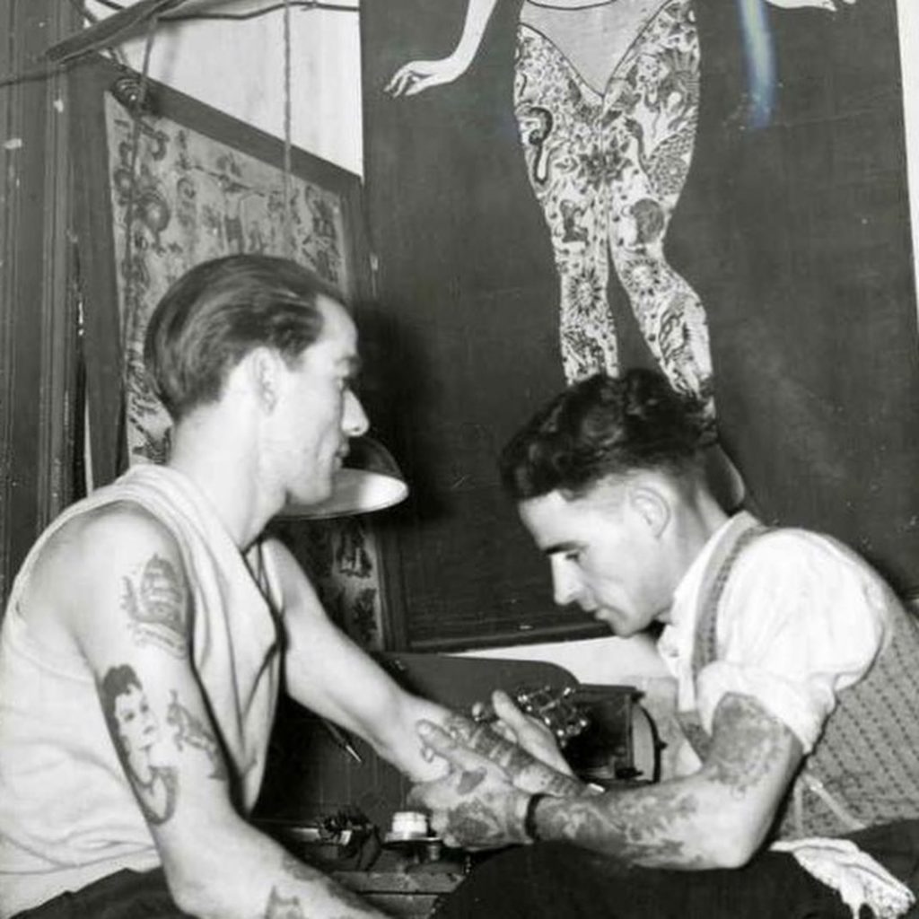 R.M Reynolds tattooing a sailor from the Royal Australian Navy, in his Melbourne studio, c.1940 vintage tattoo historical archive photograph