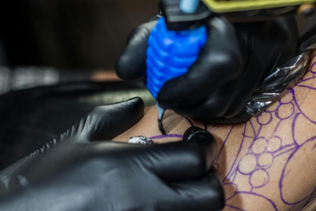tattoo artist wearing black nitrile gloves for studio safety