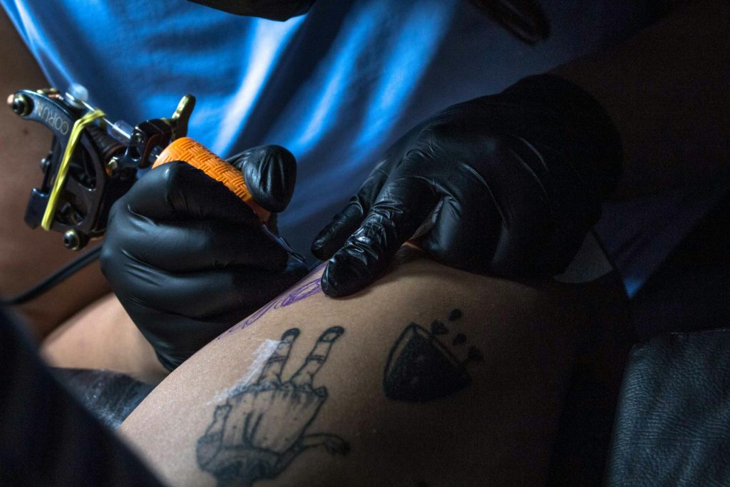 tattoo artist wearing black nitrile gloves for studio safety