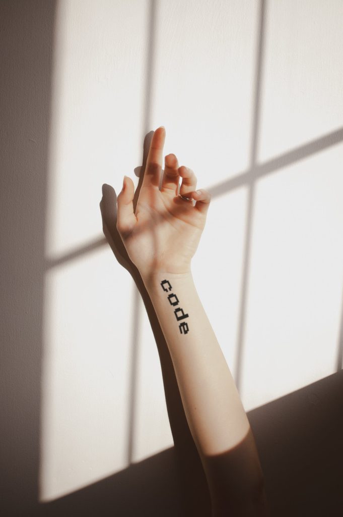 girl arm displaying code lettering tattoo mockup