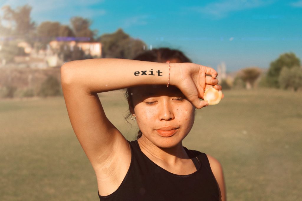 exit lettering tattoo girl showing arm