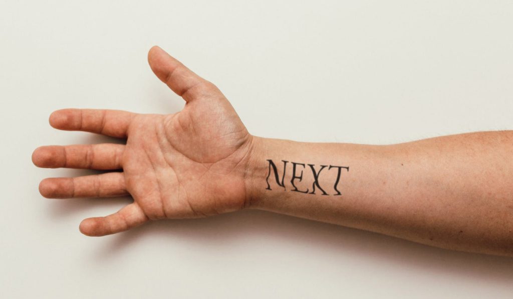 man arm displaying next lettering tattoo mockup