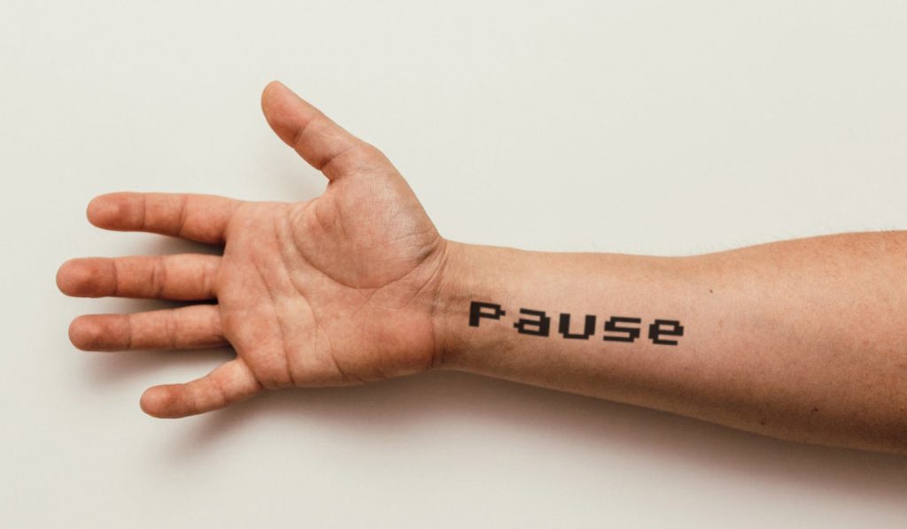 man arm displaying pause lettering tattoo mockup