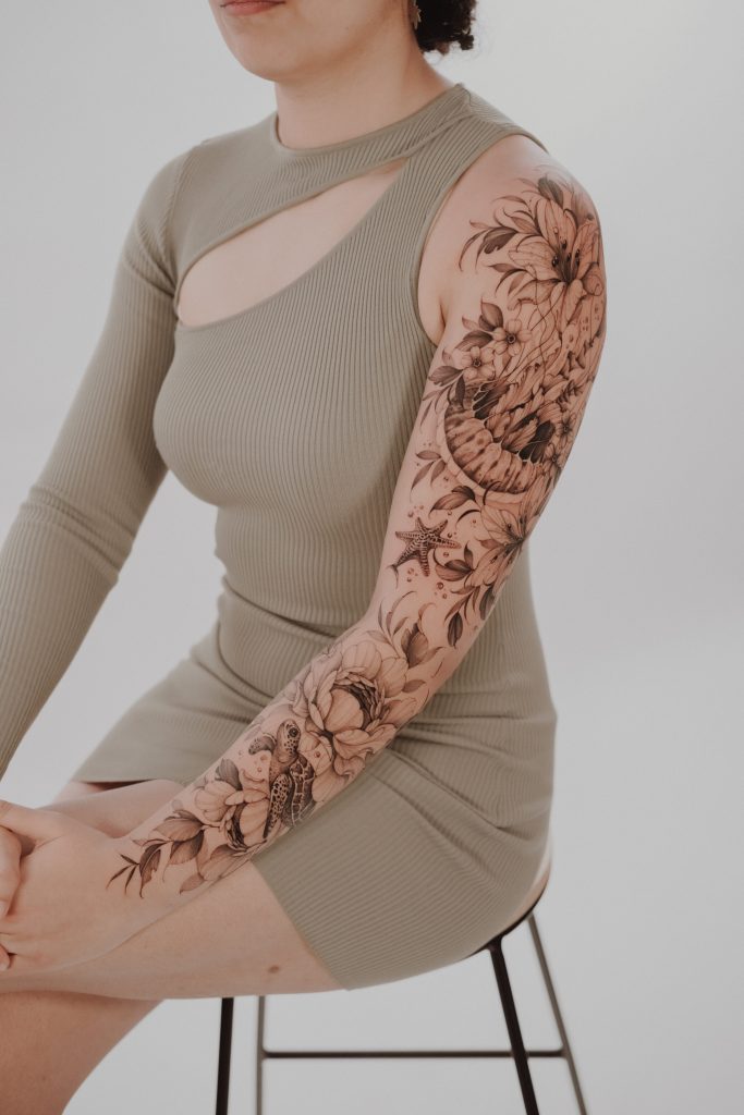 beautiful flower sleeve tattoo in black & grey by Mateus de Assis