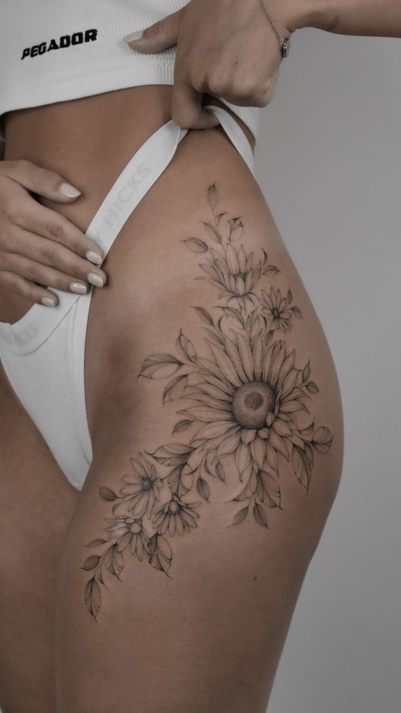 amazing flower bouquet tattoo on the side leg by Asya Teryaeva