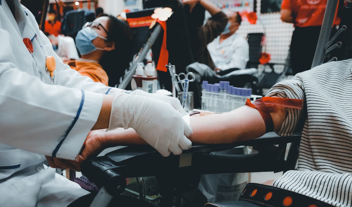 A healthcare worker assisting a blood donor at a donation center