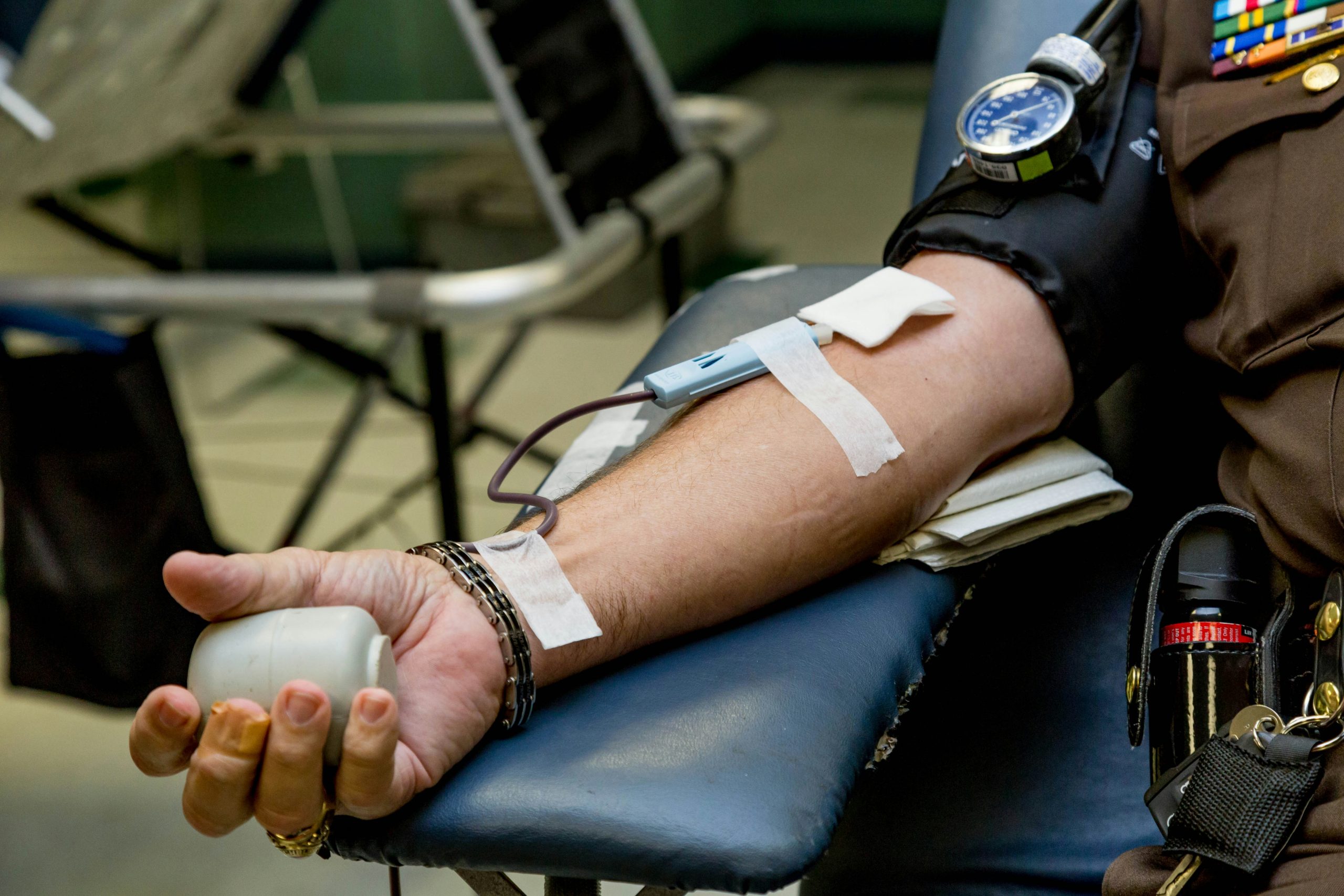 A person donating blood at a Red Cross blood drive with a needle and tube in their arm